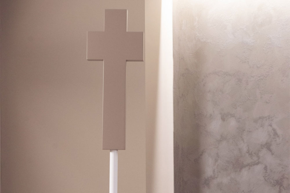 crocifisso color beige in legno illuminato da luce