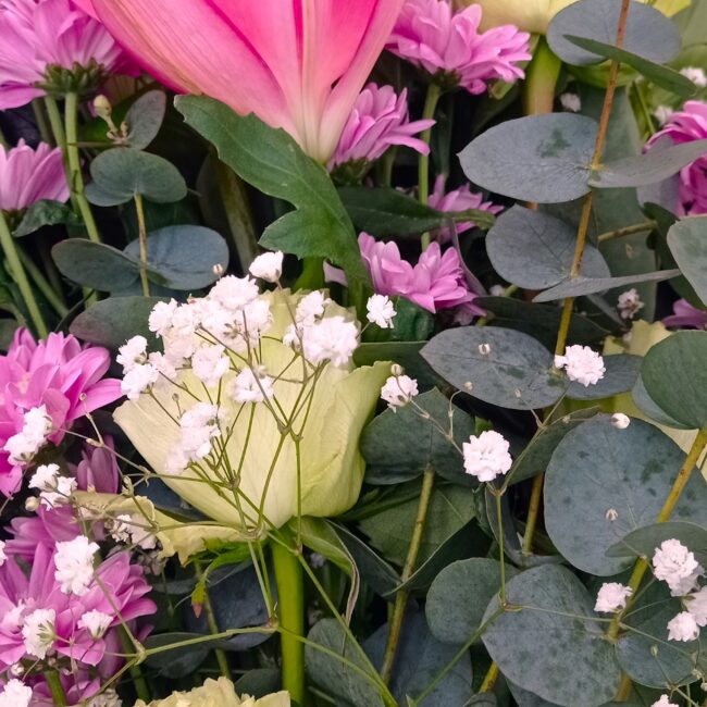 mazzo di fiori formato da rose, ranuncoli e gigli rosa e viola