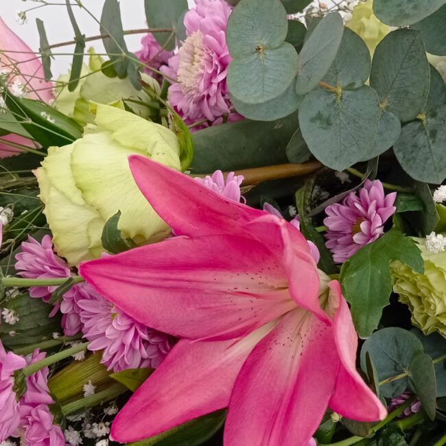 mazzo di fiori fucsia per cerimonia funebre con rose, gigli e ranuncoli