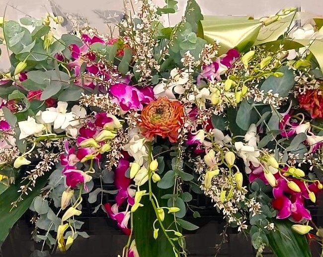 corona per funerale con fiori rosa bianchi e verdi