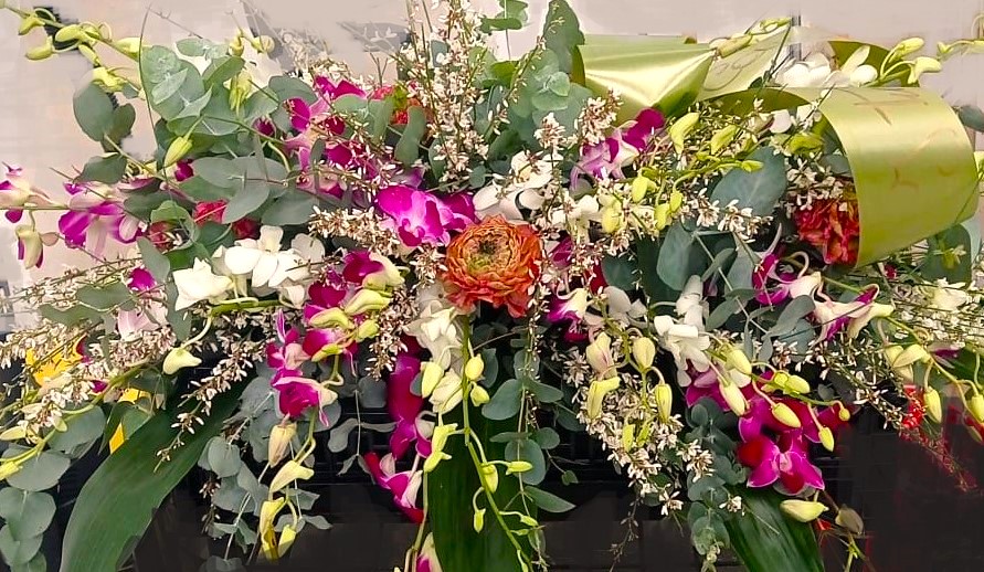 corona per funerale con fiori rosa bianchi e verdi