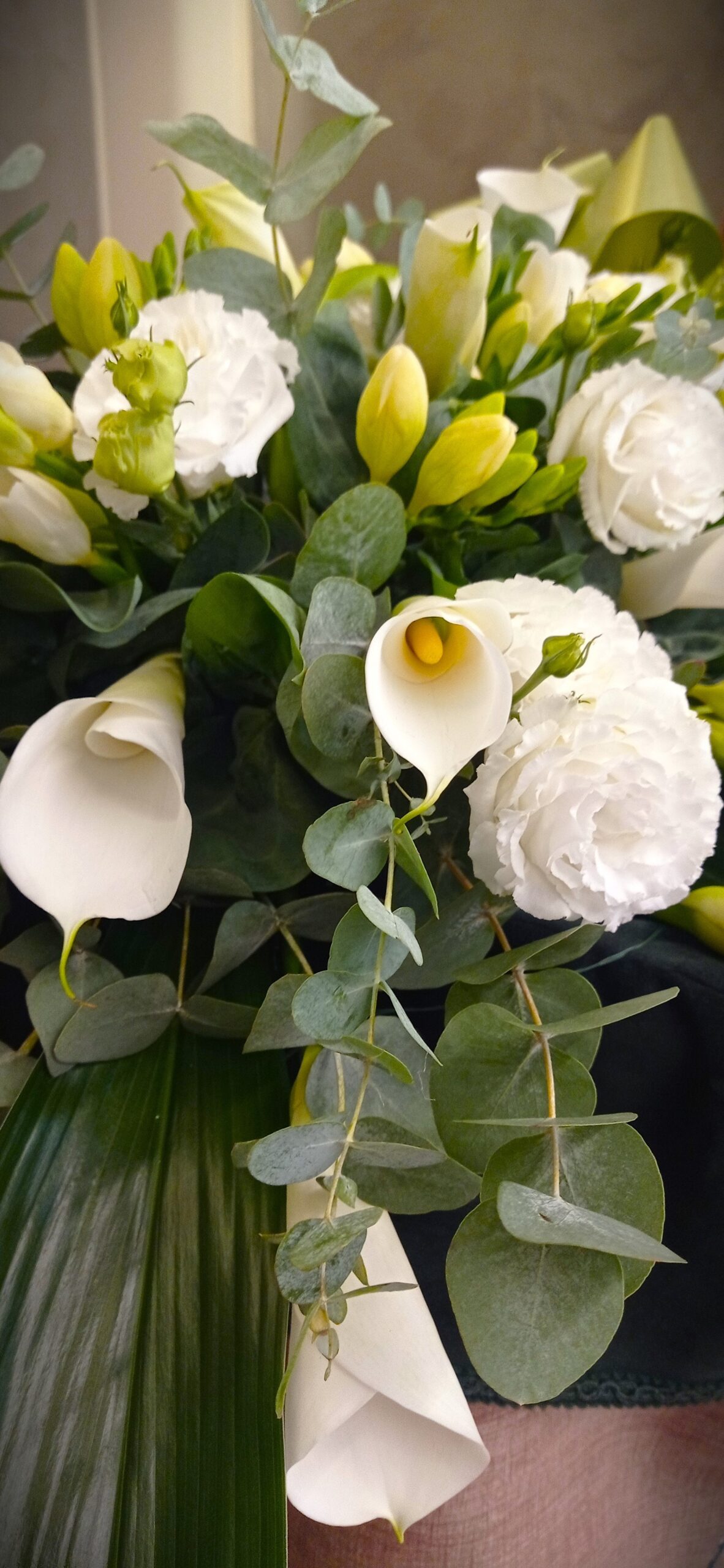 mazzo di fiori bianchi con calle e ranuncoli su una bara