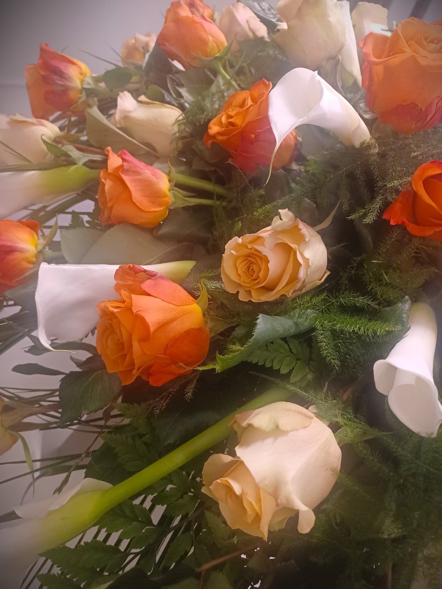 mazzo di rose arancioni con calle bianche