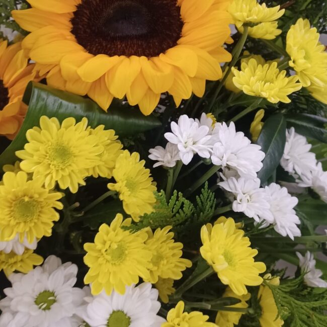 girasoli gialli e fiori bianchi e gialli in una composizione floreale