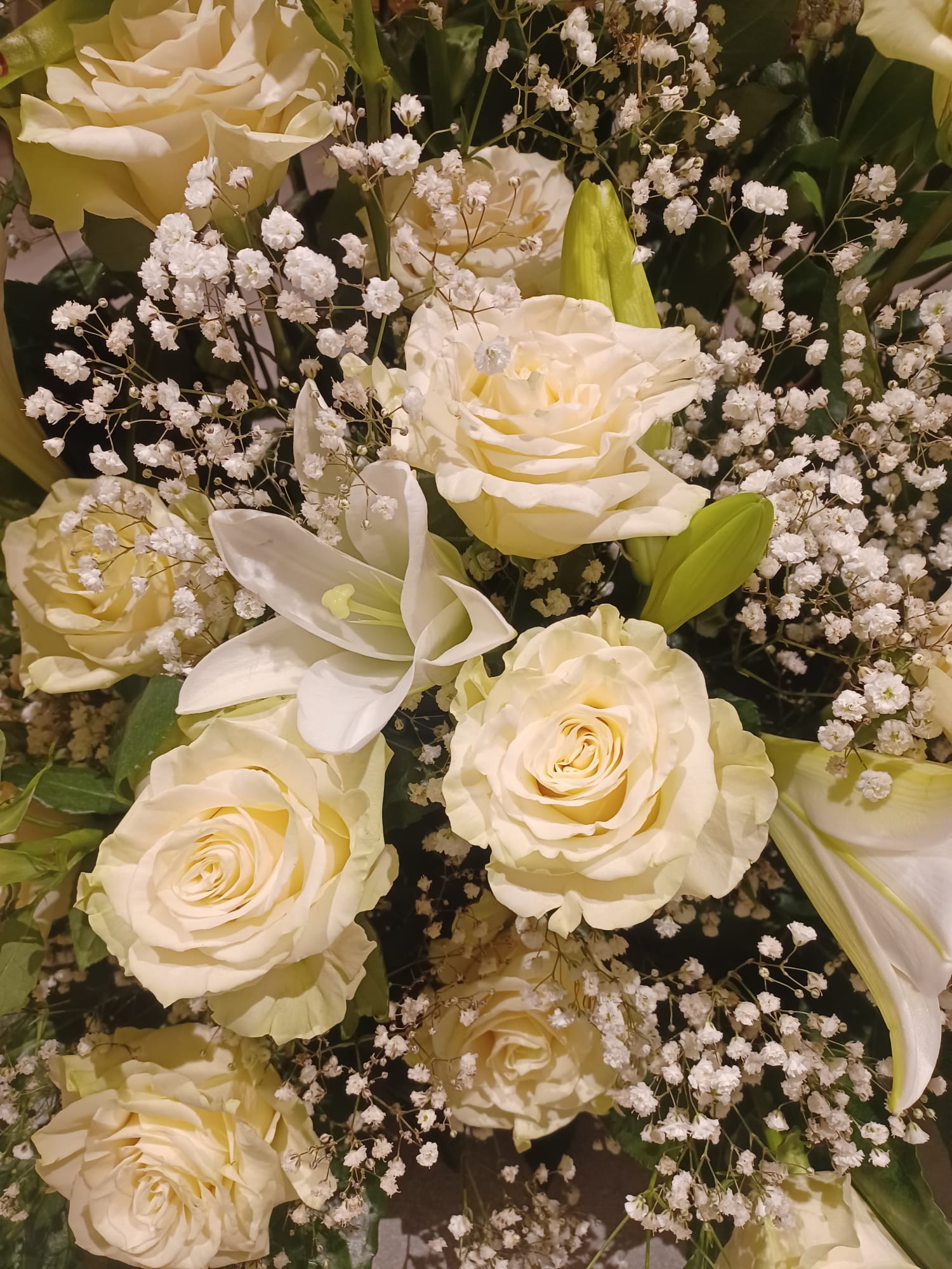rose bianche, gigli e gypsophila per mazzo funerale