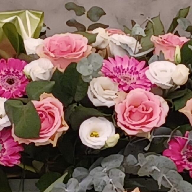 mazzo di rose rosa e bianche in una corona funebre