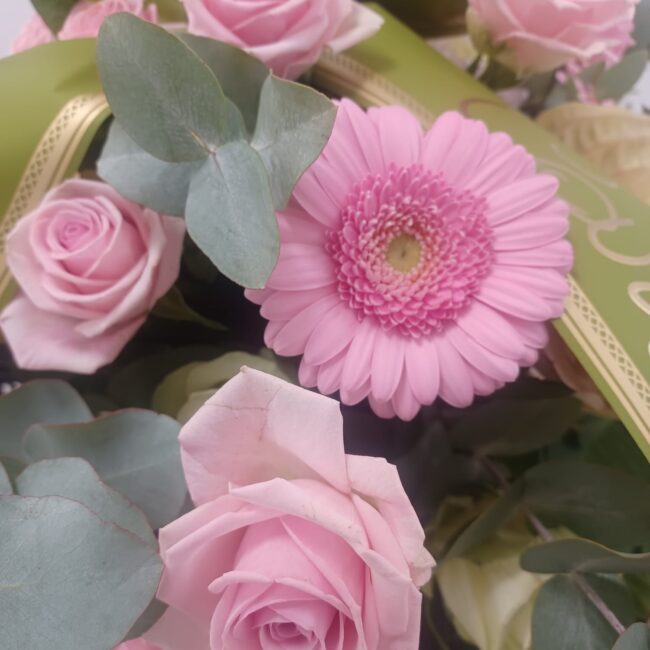 rose e gerbere rosa su corona funebre