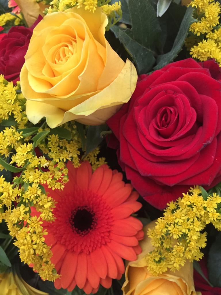 composizione funebre mista di fiori sui colori del giallo e roso