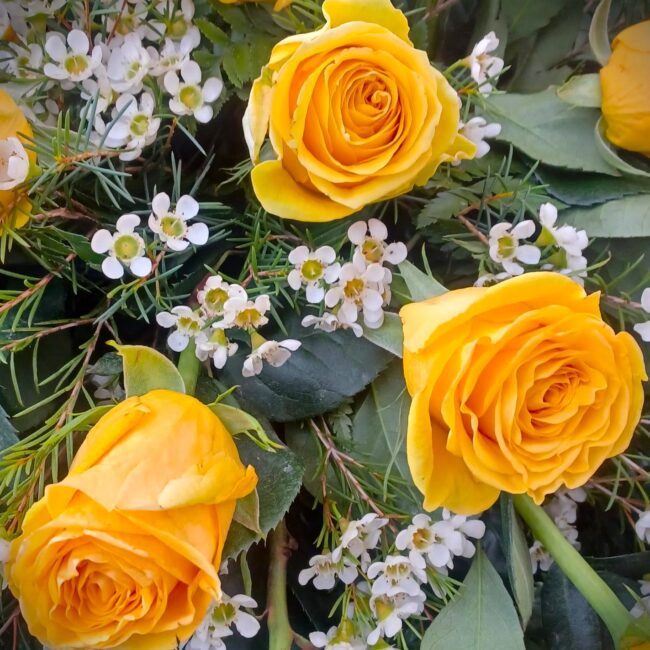 mazzo di fiori con rose gialle e fiorellini bianchi