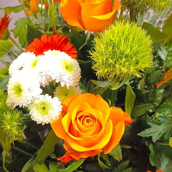 composizione floreale con rose, gerbere e crisantemi arancioni e bianchi