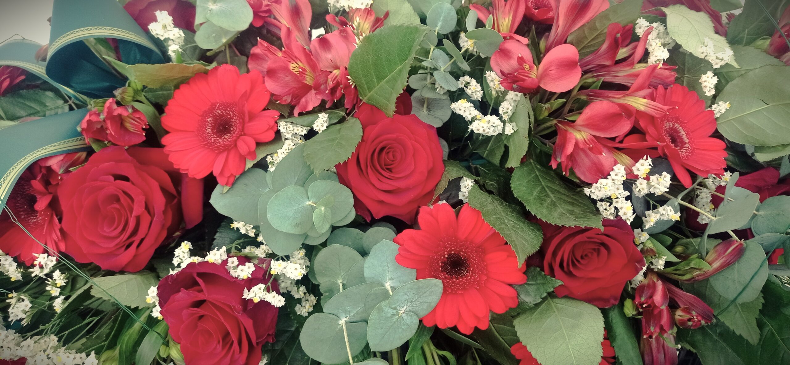 composizione di fiori rossi con rose gerbere e agapanthus