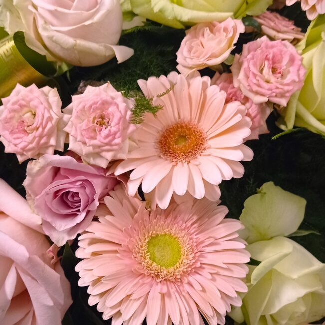 corona florale funebre nella tonalità del rosa e bianco con gerbere e rose