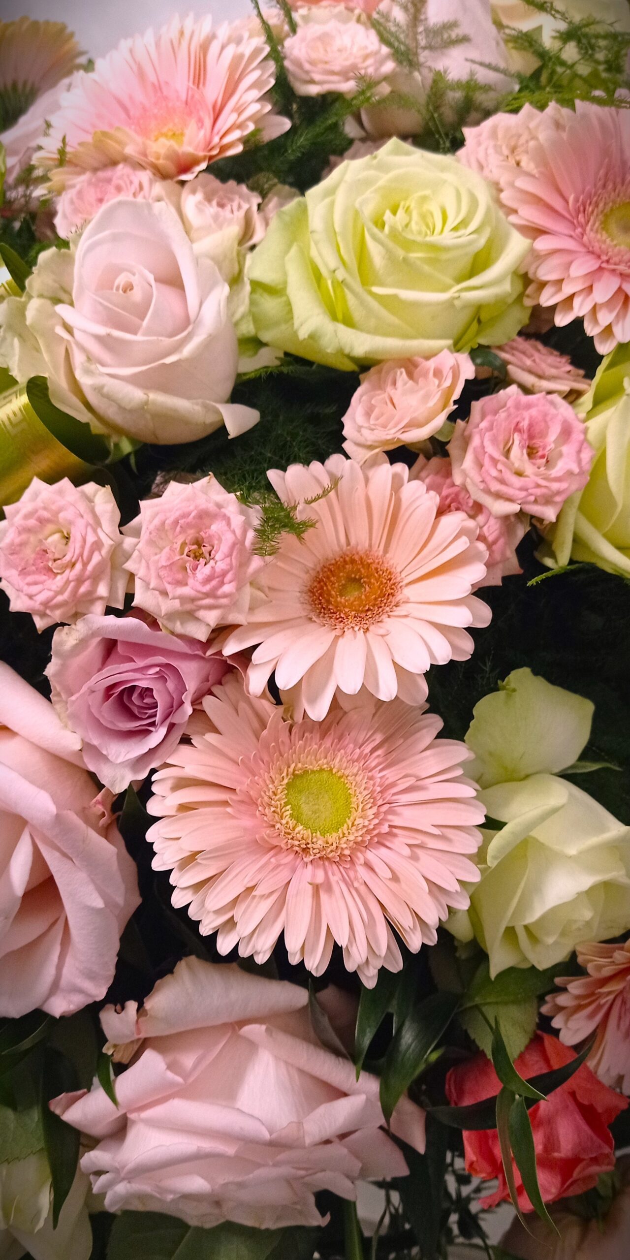 corona florale funebre nella tonalità del rosa e bianco con gerbere e rose