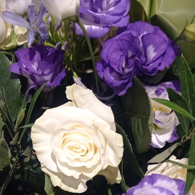 rosa bianca e fiore lisianthus viola in una composizione per funerale