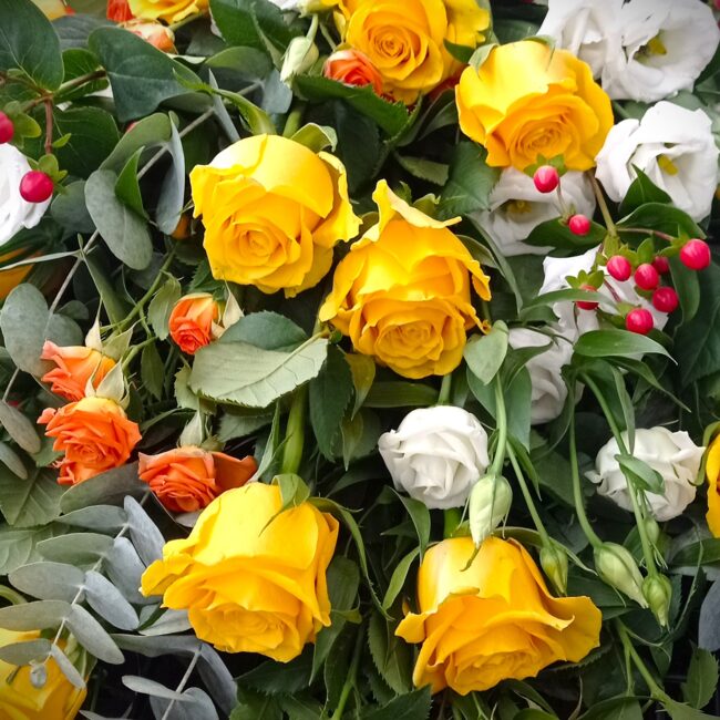 composizione di rose gialle, rancioni e rosa per corona di fiori funerale