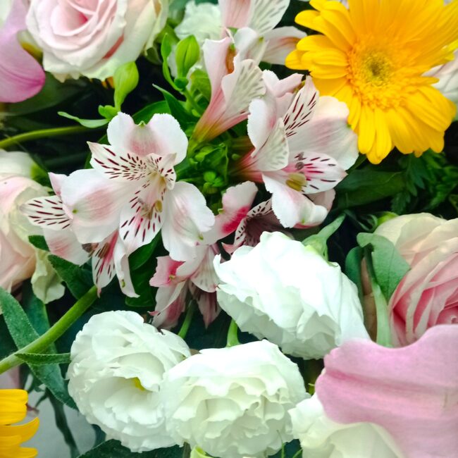 composizione fiori per bara con gerbere, rose e roselline bianche e rosa