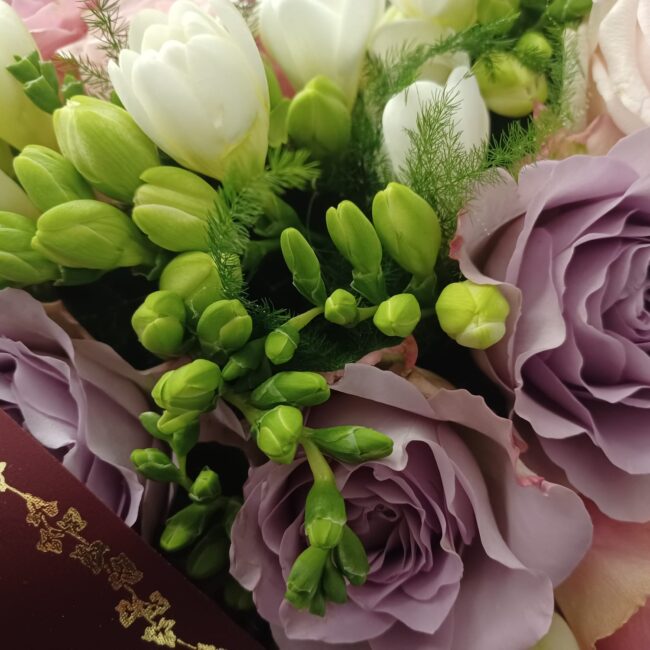 corona di fiori per funerale con freesia bianca e rose lilla