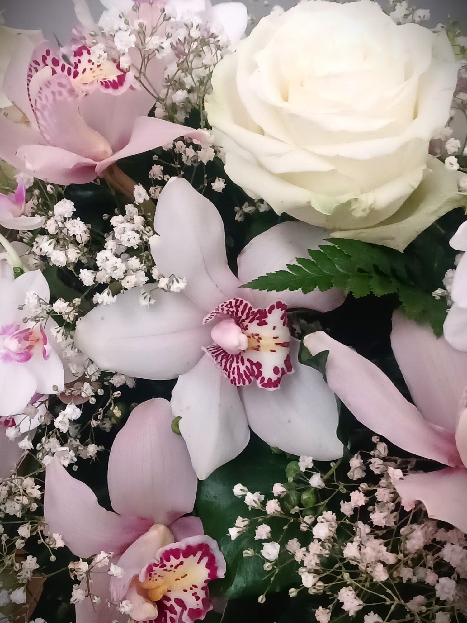 composizione florale composta da rose e orchidee rosa