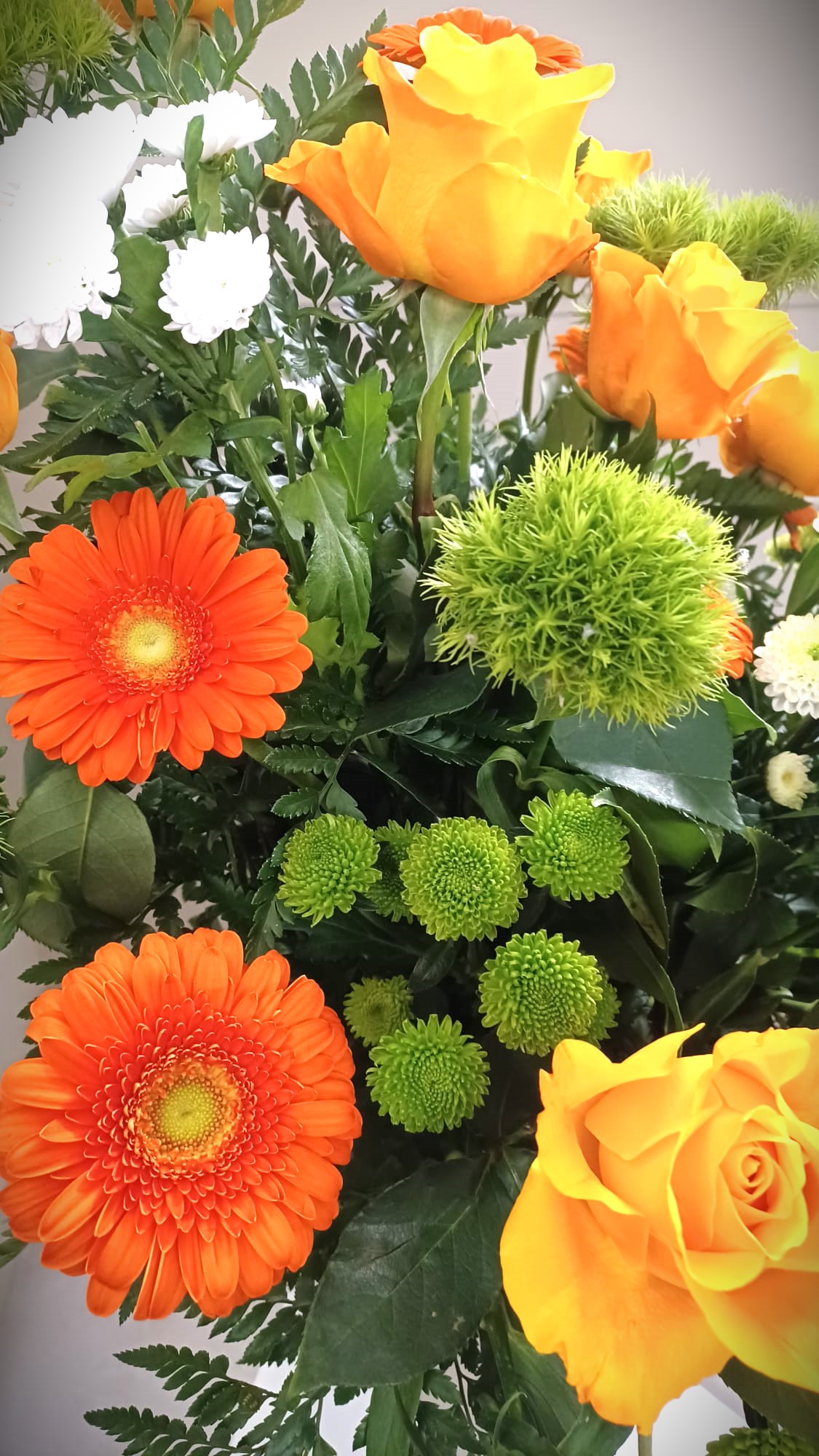 composizione floreale con crisantemi, rose e gerbere di colori arancione e gialli