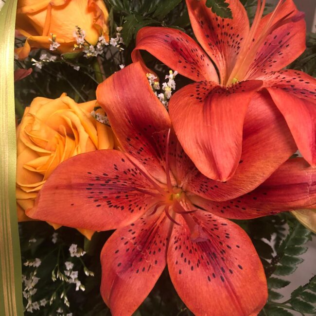 due gigli arancioni con due rose gialle