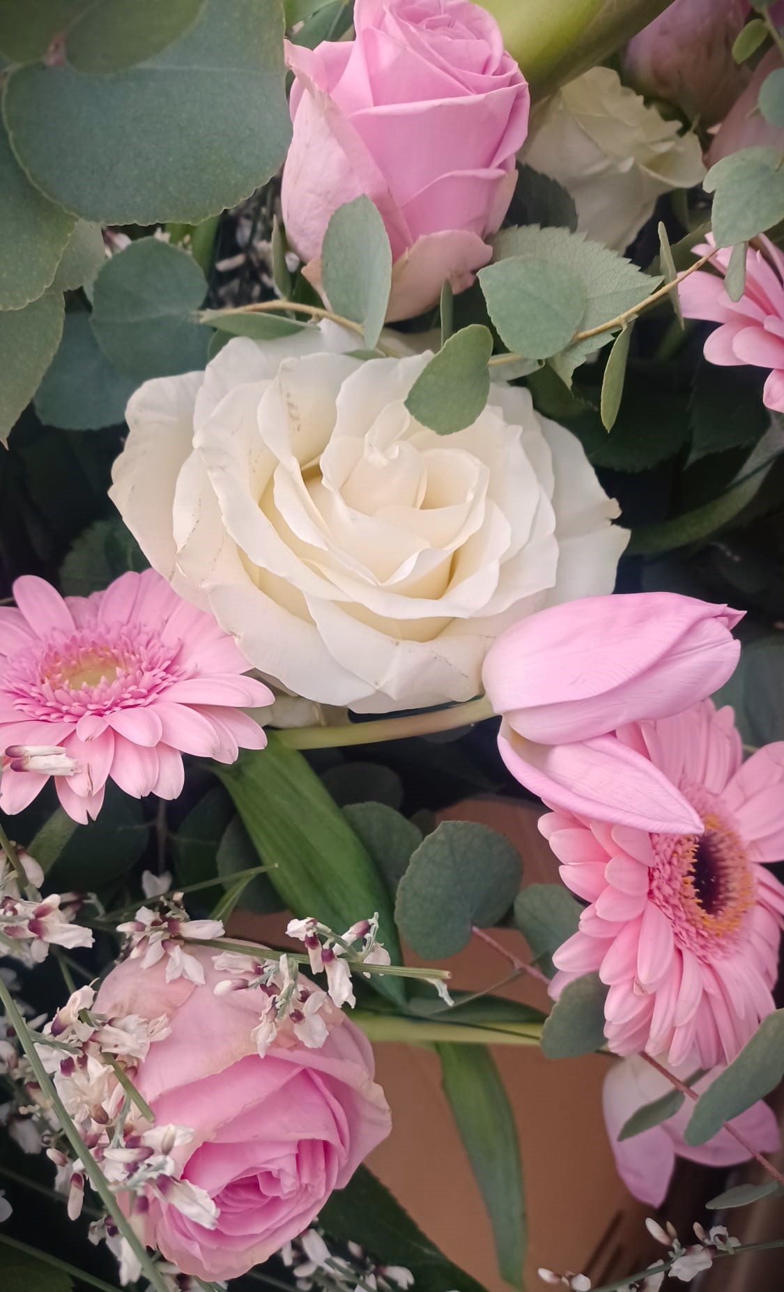 rose e gerbere rosa in una composizione funebre